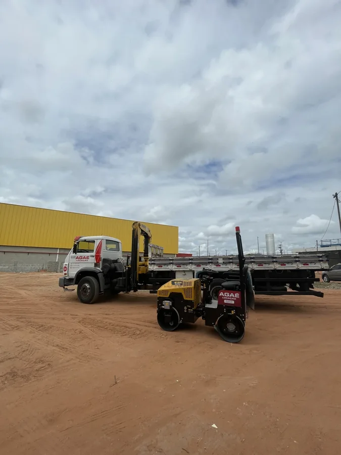 Caminhão Agaé Locação e rolo compactador no local da obra